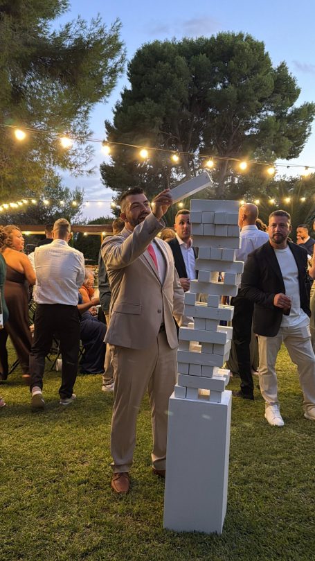 Invitado colocando una pieza sobre el Jenga gigante durante el cóctel